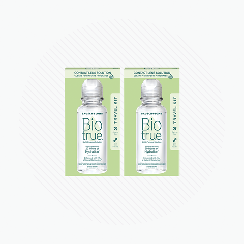 Two boxes of Bausch + Lomb BioTrue Multipurpose Contact Lens Solution Travel Kit (2x 2oz 60mL) rest on a white, striped background. Each box contains a clear bottle with the brand and product name, ideal for maintaining silicone hydrogel lenses while traveling.