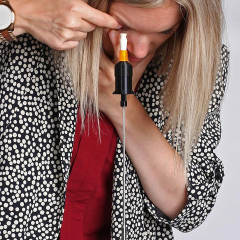 A person with long blonde hair in a polka dot jacket adjusts the S5 Inserter for scleral lens insertion from Augmented Vision Labs during their free video training session.