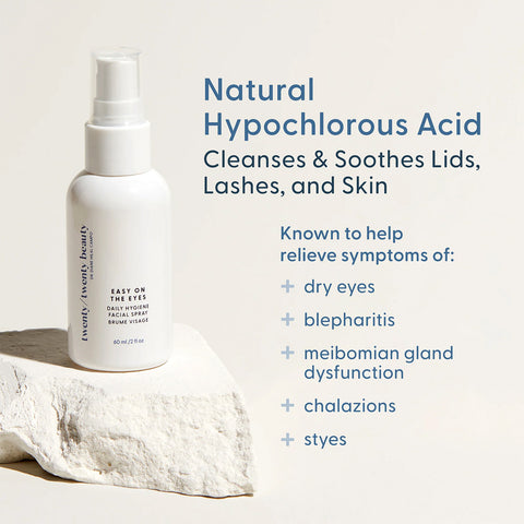 A white spray bottle with the label Twenty Twenty Daily Hygiene Facial Spray is set on a stone surface. The text states: Natural Hypochlorous Acid—ophthalmologist-approved to cleanse and soothe lids, lashes, and skin. Ideal for dry eyes, blepharitis, meibomian gland dysfunction, chalazions, and styes.
