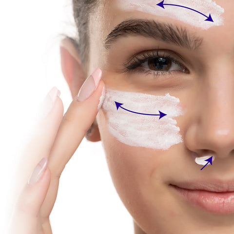 Close-up of someone applying Omega 3 Innovations Barristrong Skin Cream for Sensitive Eyes and Irritated Eyelids using fingers on their forehead, cheeks, and upper lip. Blue arrows indicate application direction against a pristine white background.