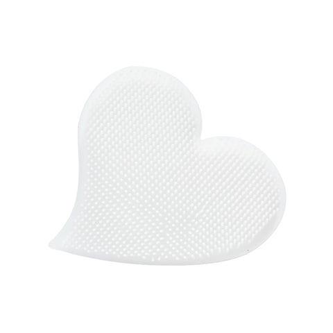 The We Love Eyes Eyelid Scrub Mitt is a heart-shaped, white silicone brush cleaner adorned with small textured bumps, resembling an eyelid scrub, showcased on a plain white background.