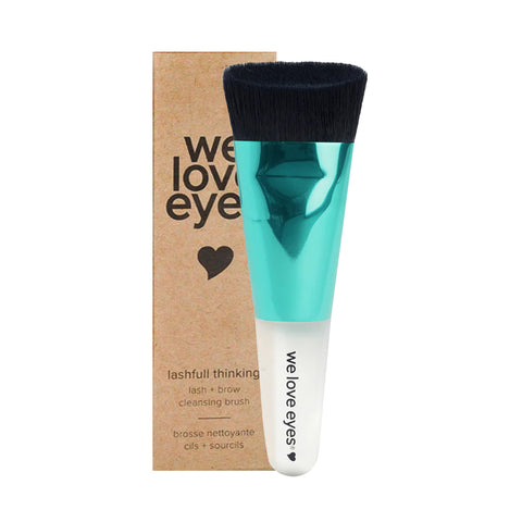 A teal and white eyelash cleansing brush with black bristles, labeled We Love Eyes, sits beside packaging reading Lashfull Thinking lash & brow cleansing brush with a heart graphic. Its vegan, cruelty-free, and perfect for eyelid margin health.