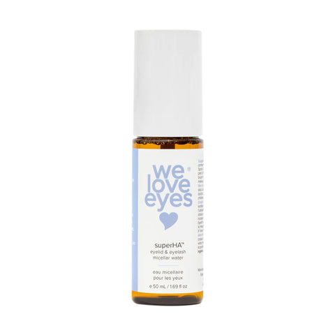 The We Love Eyes superHA Eyelid & Eyelash Micellar Water Make-up Remover (50mL) is displayed with a cylindrical bottle, white cap, blue text, and heart symbol. It promotes eyelid health and is perfect for removing eye makeup.