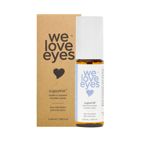 The We Love Eyes superHA Eyelid & Eyelash Micellar Water Make-up Remover (50mL) sits next to its packaging. The white bottle with blue text complements the brown package with white and blue details, perfect for removing eye makeup and promoting eyelid skin health.