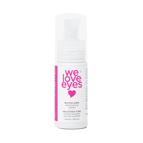 A 50 ml We Love Eyes Tea Tree Water Eyelid Foaming Cleanser with pink text and a pump dispenser sits on a white background, providing gentle, pH-balanced care.