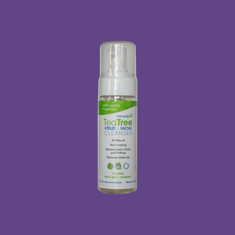 A bottle of EyeEco TranquilEyes Age-Defying 1% Tea Tree Eyelid & Facial Cleanser, for reducing dark circles and puffiness, stands upright on a purple background with its white pump cap and green-and-white label visible.