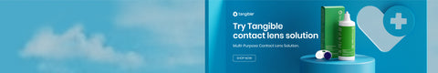 A blue advertisement for Tangible contact lens solution, featuring a green bottle and box on a podium. Text reads, Try Tangible contact lens solution. Multi-Purpose Contact Lens Solution. A cloud and a heart icon with a plus sign are visible.