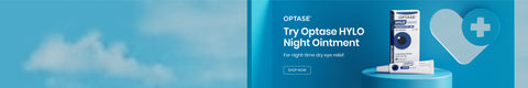A blue advertisement for Optase HYLO Night Ointment, featuring a package of the ointment beside a heart symbol with a medical cross. The text reads, Try Optase HYLO Night Ointment for night-time dry eye relief.