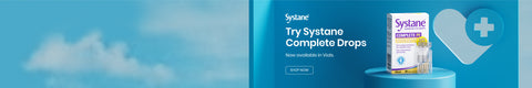 A box of Systane Complete Drops is displayed on a blue surface with a blue background. Text reads, Try Systane Complete Drops. Now available in Vials. A white medical cross in a heart shape is in the background.