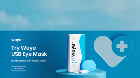 Advertisement for a Weye USB Eye Mask. The image shows the product box next to the eye mask on a round platform. The background is blue with a large heart icon featuring a medical cross. Text reads: Try Weye USB Eye Mask. Heating mask for eyelid relief.