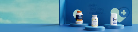Three bottles of supplements are displayed on blue podiums with the text Daily Eye Care Simplified in the background. The setting is minimalist with a teal backdrop.