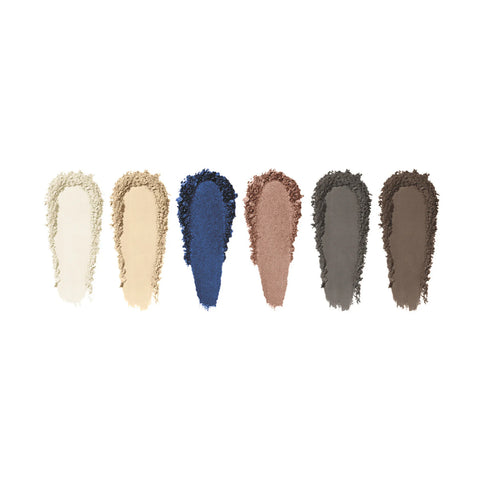Six makeup swatches featuring white, beige, tan, blue, rose, and taupe shades from the Eyes are the Story Eyeshadow Palette (6 Colors) by Eyes are the Story showcase a textured appearance. These matte eyeshadows deliver an innovative formula with high-pigment hues for striking vibrant looks.