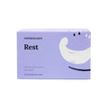 A purple CorneaCare box labeled Self Heating Warm Compresses contains 30 masks for soothing eye relief, featuring abstract white and black designs, ideal for comforting dry eyes.