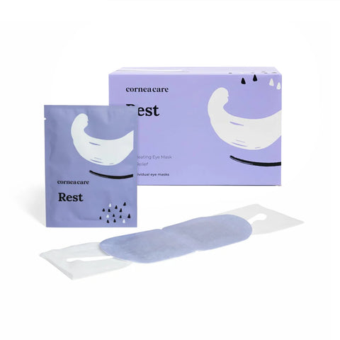 A purple CorneaCare Rest box includes a matching eye mask pouch and self-heating warm compress, featuring a crescent and dot design in black and white, offering soothing relief for dry eyes. Product: CorneaCare Self Heating Warm Compresses (30ct). Brand: CorneaCare.