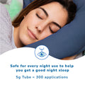 A person peacefully sleeping with a slight smile on a navy blue pillow. Below, the text reads: Optase Hylo Night Ointment is safe for nightly use, ensuring a restful nights sleep. Provides nighttime relief for dry eyes. Preservative-free 5g tube offers 300 applications, followed by an eye with droplets icon.