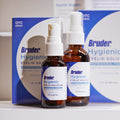 Displayed are bottles of Bruder Hypochlorous Hygienic Eyelid Solution, ideal for soothing dry eyes. They feature white spray tops and detailed labels. The packaging boxes are partially visible in the background.