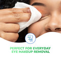A close-up of someone using an Optase Tea Tree Oil Eyelid Wipe, free from preservatives, to remove orange eyeshadow. The text at the bottom says, Ideal for daily eye makeup removal beside an icon of an eye and makeup brush.