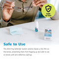 A person holds eyeglasses above a table with the ZEISS Fog Defender System Anti-Fog Spray for Glasses, which includes 1 spray bottle and 1 microfiber cloth. A green shield icon assures it is Safe to Use, highlighting its effectiveness on anti-fog lenses from Zeiss.